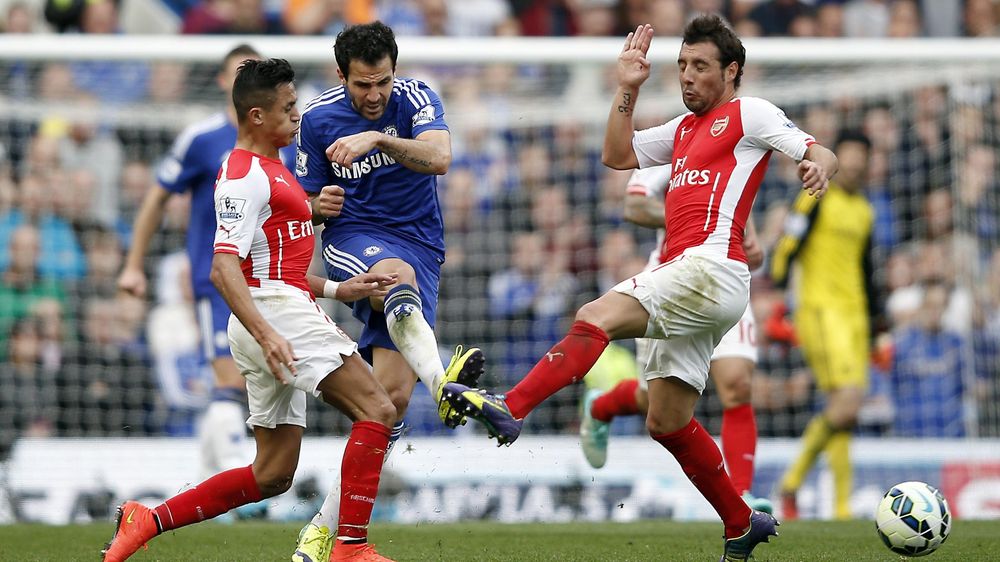 Chelsea's Cesc Fabregas (2nd L) shoots between Arsenal's Alexis Sanchez (L) and Santi Cazorla (R)