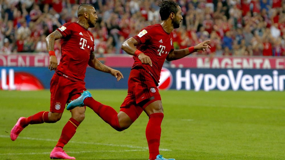 Bayern Munich's Medhi Benatia celebrates with Arturo Vidal (L) after scoring a goal against Hamburg during their Bundesliga match in Munich, Germany August 14, 2015
