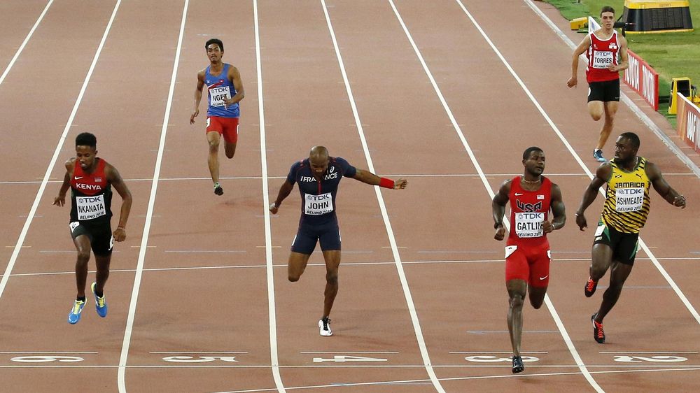 Justin Gatlin (2nd R) crosses the finish line