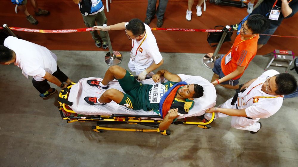 Wayde van Niekerk of South Africa is taken away by the medical team