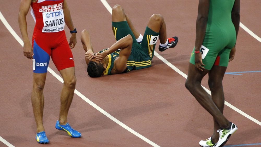 Wayde van Niekerk of South Africa falls to the ground after winning the men's 400 metres