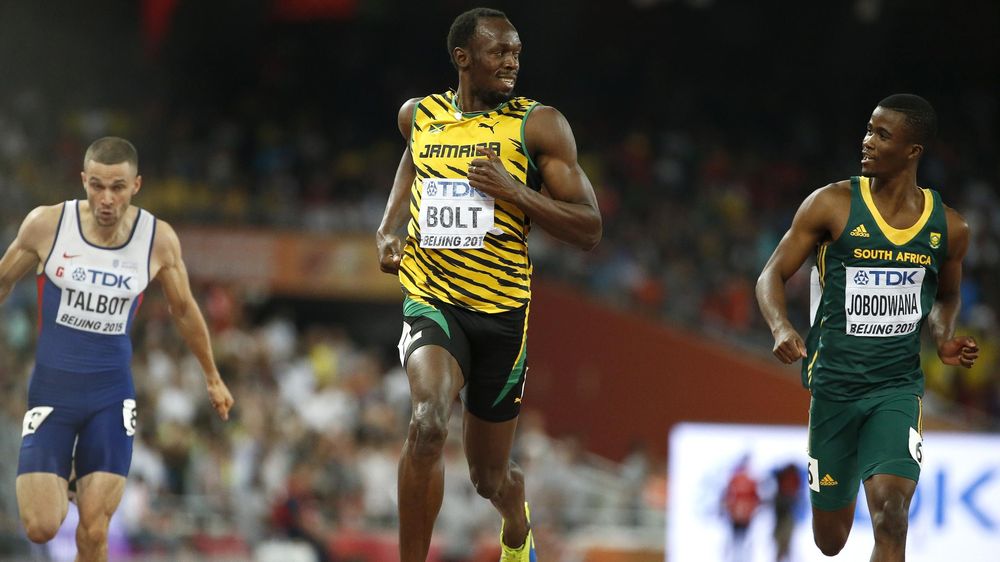 Usain Bolt of Jamaica (C) reacts after he wins the men's 200 metres semi-finals ahead of Anaso Jobodwana of South Africa (R) during the 15th IAAF World Championships at the National Stadium in Beijing, China August 26, 2015