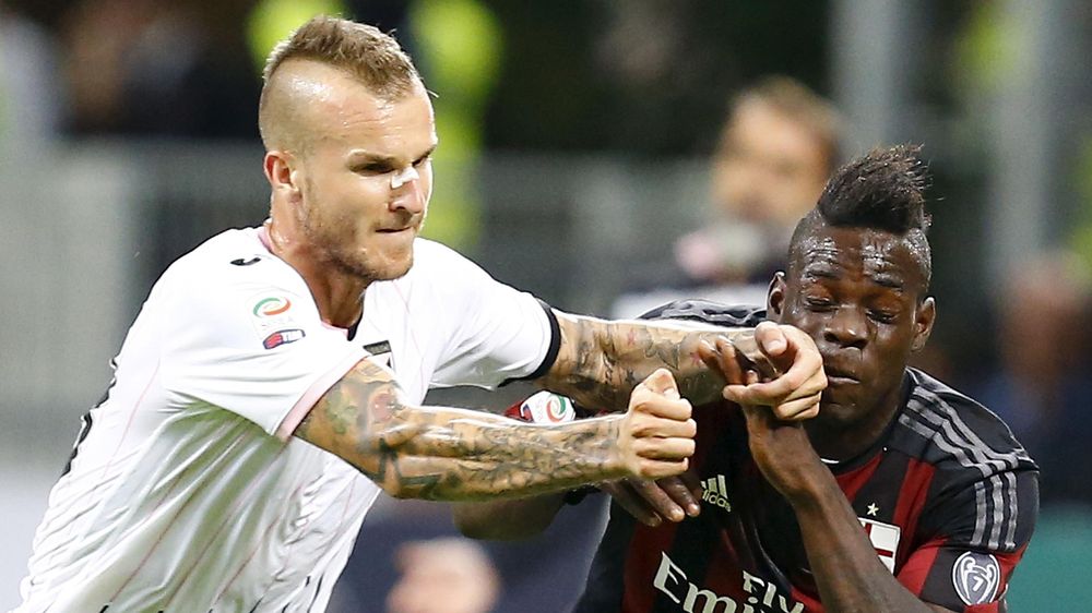 AC Milan's Mario Balotelli (R) challenges Palermo's Aljaz Struna during their Serie A soccer match at the San Siro stadium in Milan, Italy, September 19, 2015. REUTERS/Stefano Rellandini