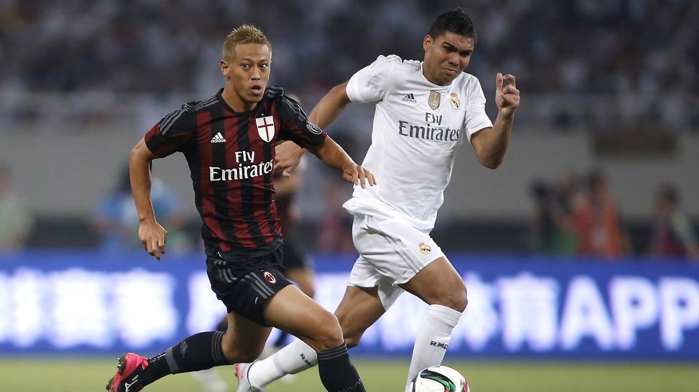 Keisuke Honda (L) of AC Milan fights for the ball with Carlos Casemiro of Real Madrid during their International Champions Cup soccer match in Shanghai, July 30, 2015. REUTERS/Aly Song