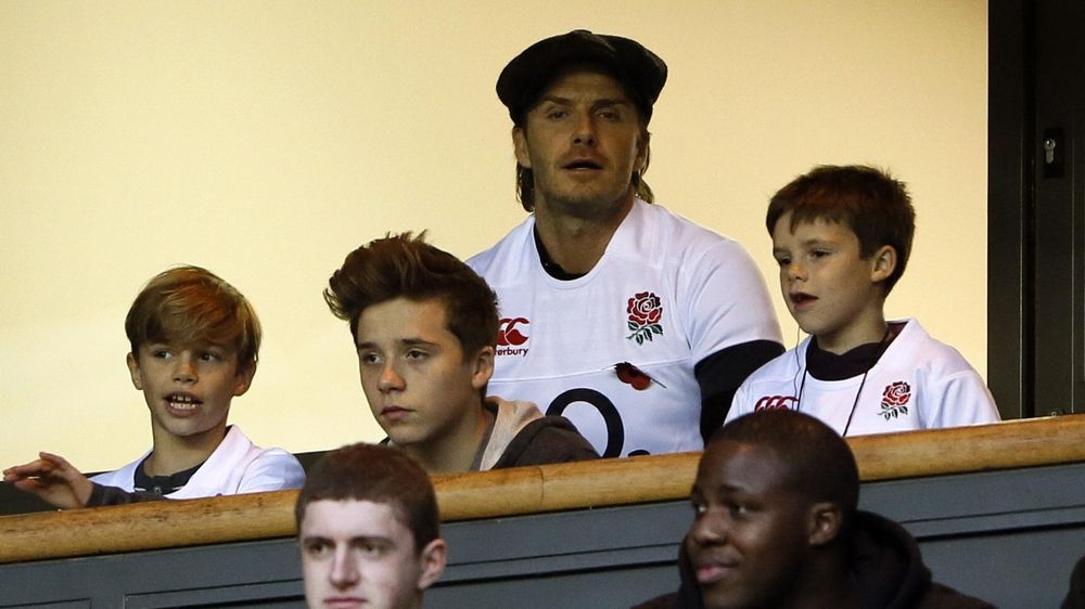 Former England footballer David Beckham (C) watches the international rugby union match between England and Argentina at Twickenham