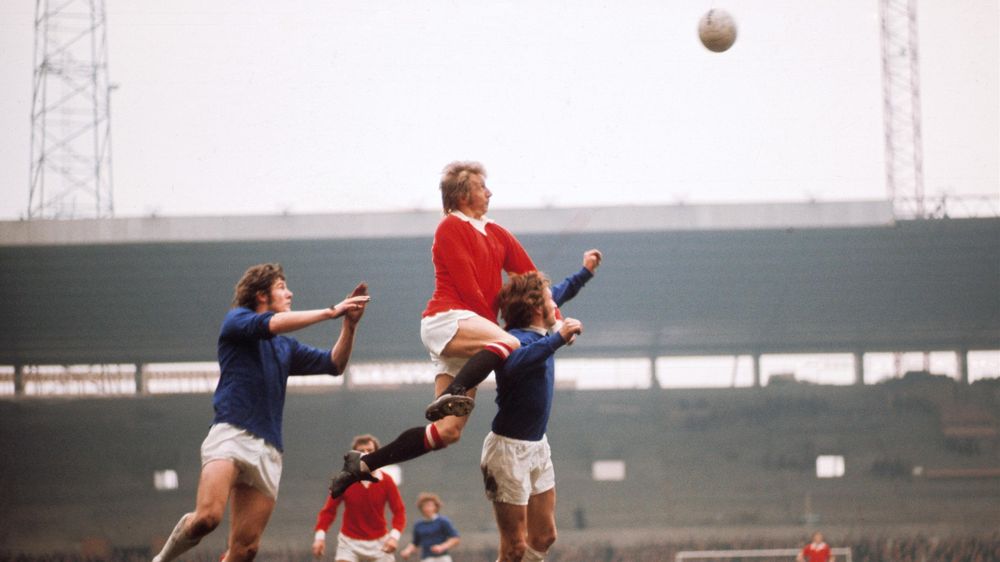 Manchester United's Denis Law rises above the Everton defence. The Everton players are Mike Lyons and Billy Kenny.