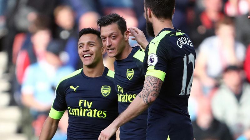 Mesut Ozil of Arsenal celebrates with Alexis Sanchez and Olivier Giroud of Arsenal after scoring a goal to make it 0-2 during the Premier League match between Stoke City and Arsenal