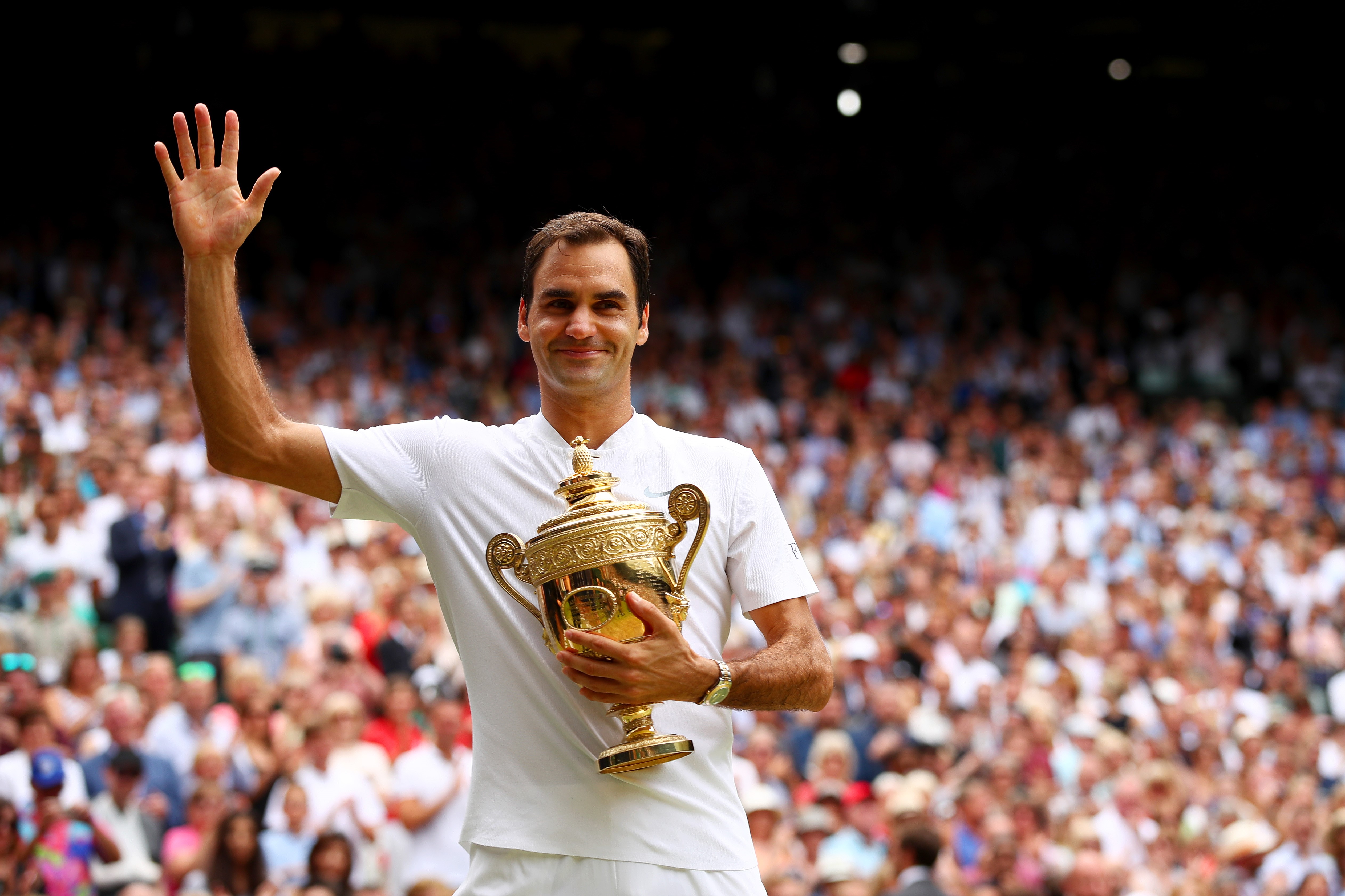 Roger Federer celebrates with the Wimbledon trophy