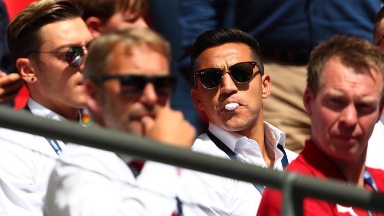 Alexis Sanchez of Arsenal looks on from the bench