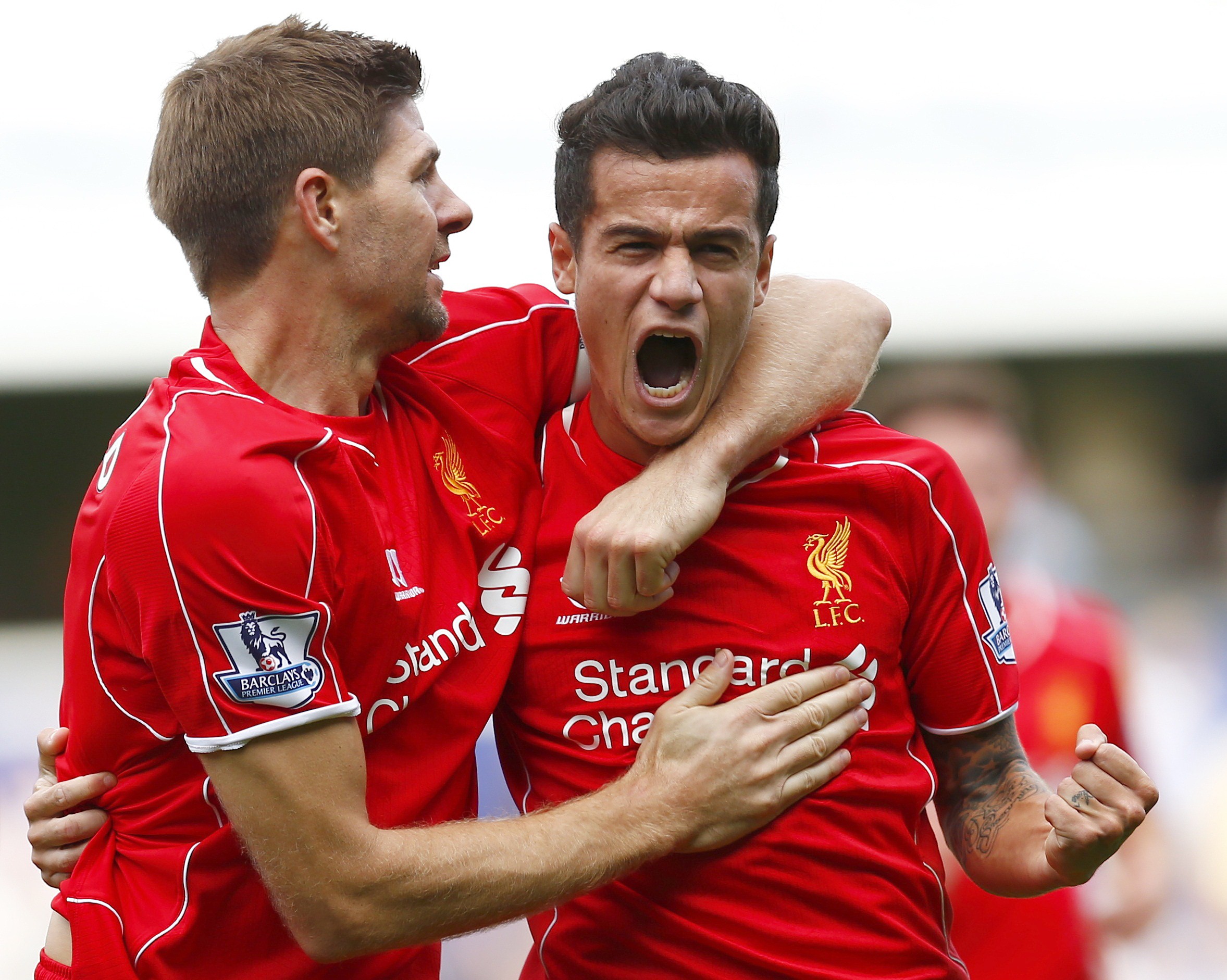 Liverpool's Philippe Coutinho (R) celebrates with Steven Gerrard after scoring during their English Premier League soccer match against Queens Park Rangers at Loftus Road in London October 19, 2014