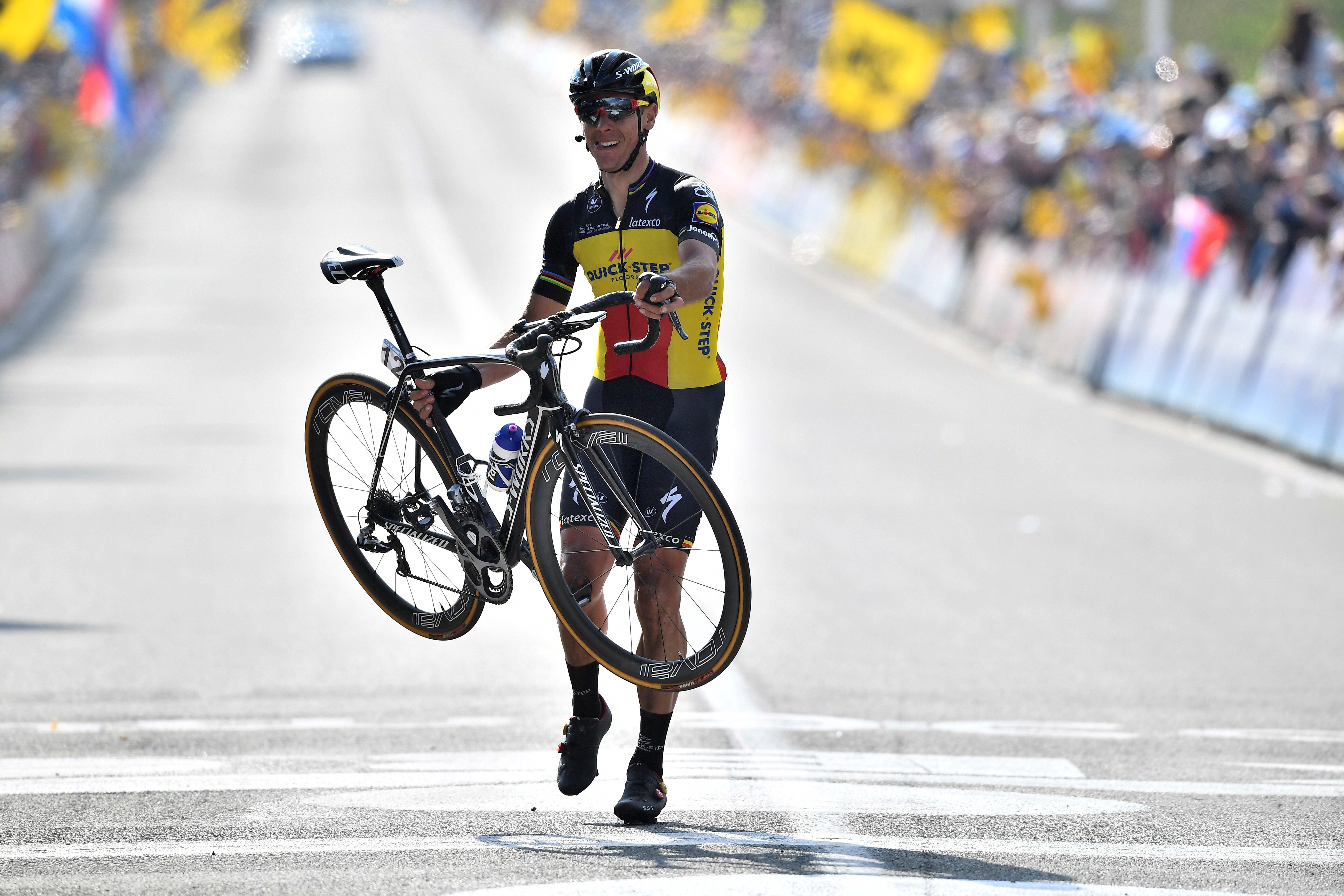 Philippe Gilbert passe la ligne du Tour des Flandres en soulevant son vélo