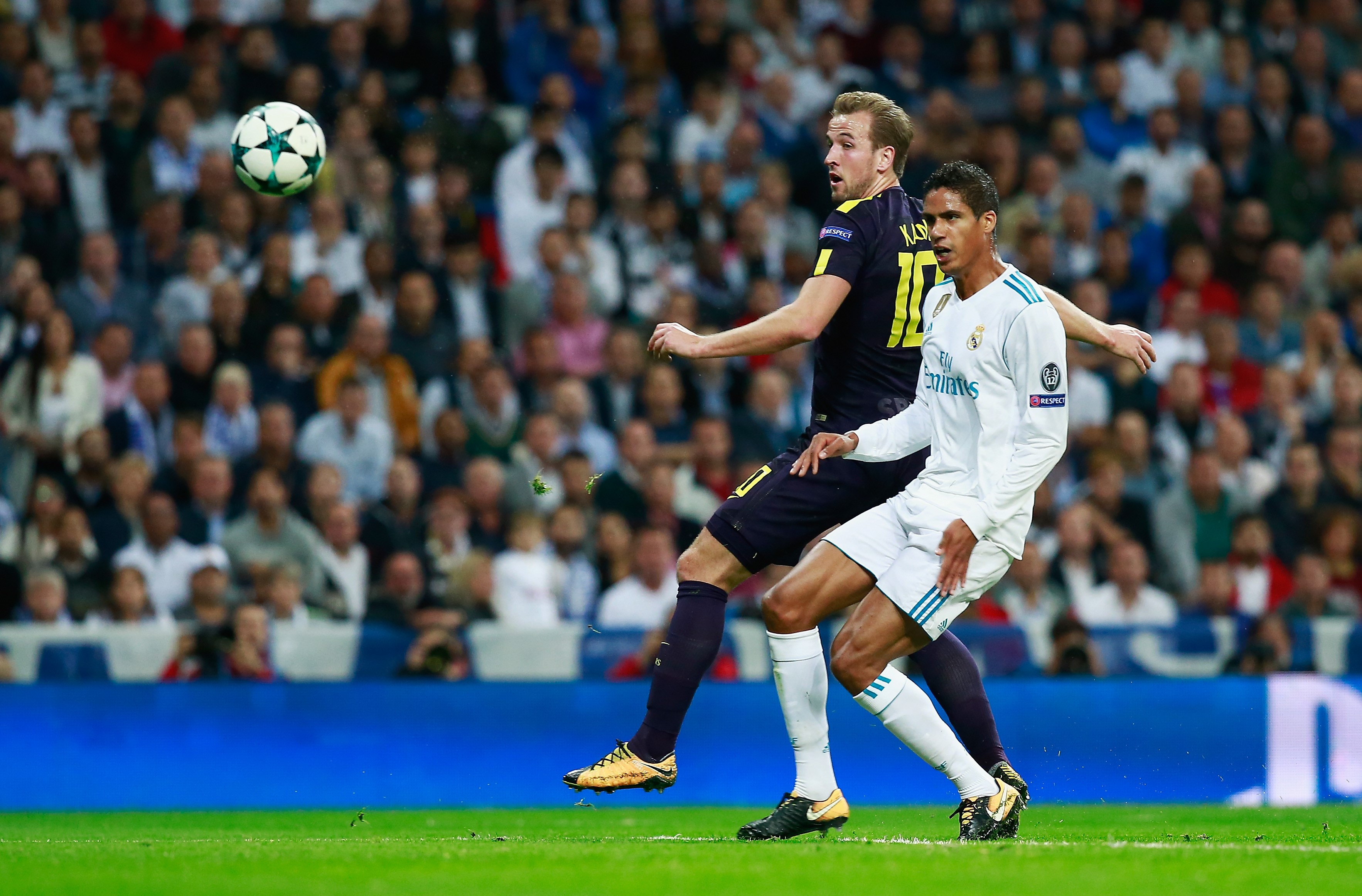 Harry Kane of Tottenham Hotspur shoots and Raphael Varane of Real Madrid deflects his shot into the net for Tottenham Hotspur first goal during the UEFA Champions League group H match between Real Madrid and Tottenham Hotspur at Estadio Santiago Bernabeu