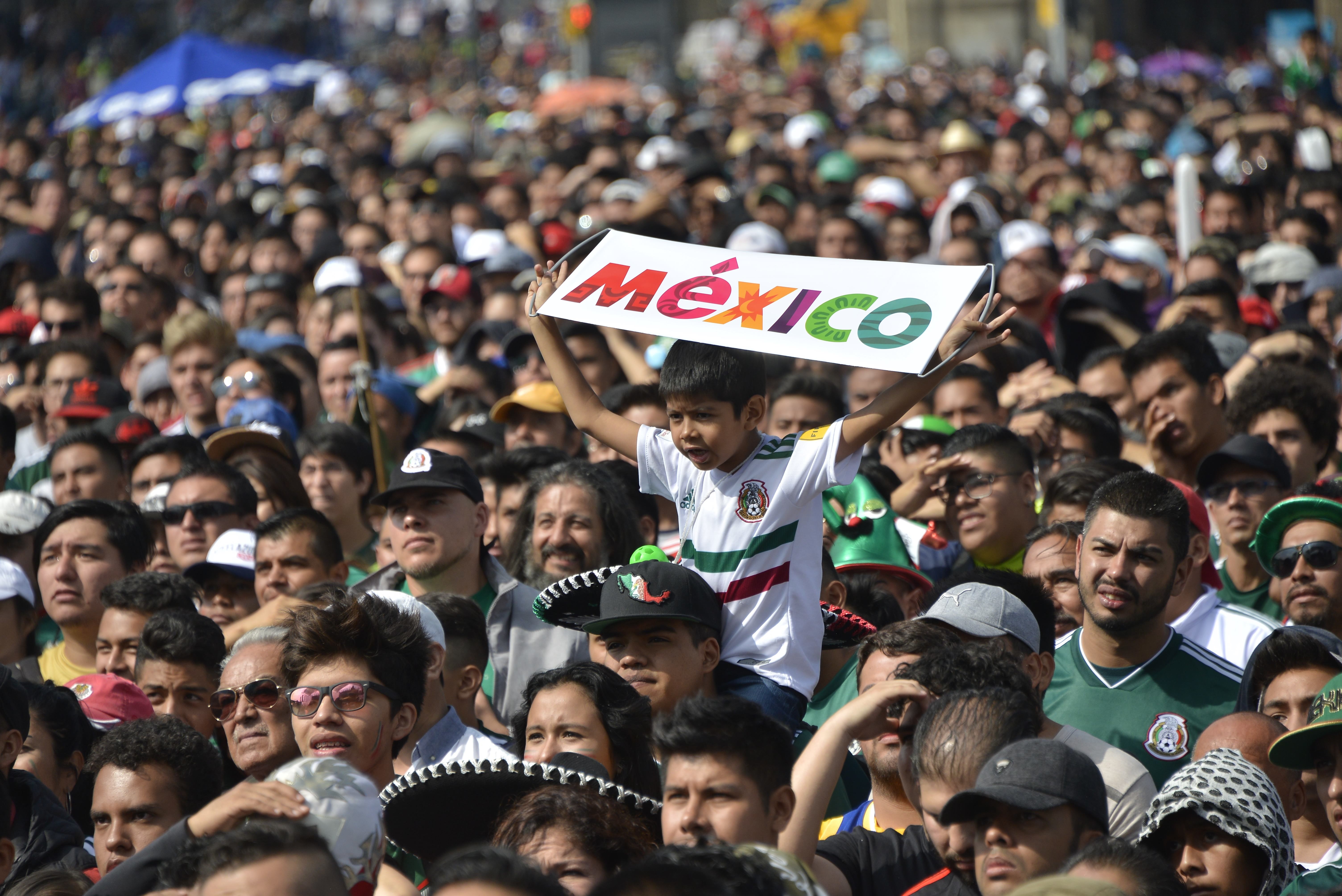 Un enfant tient un panneau Mexico dans les bras