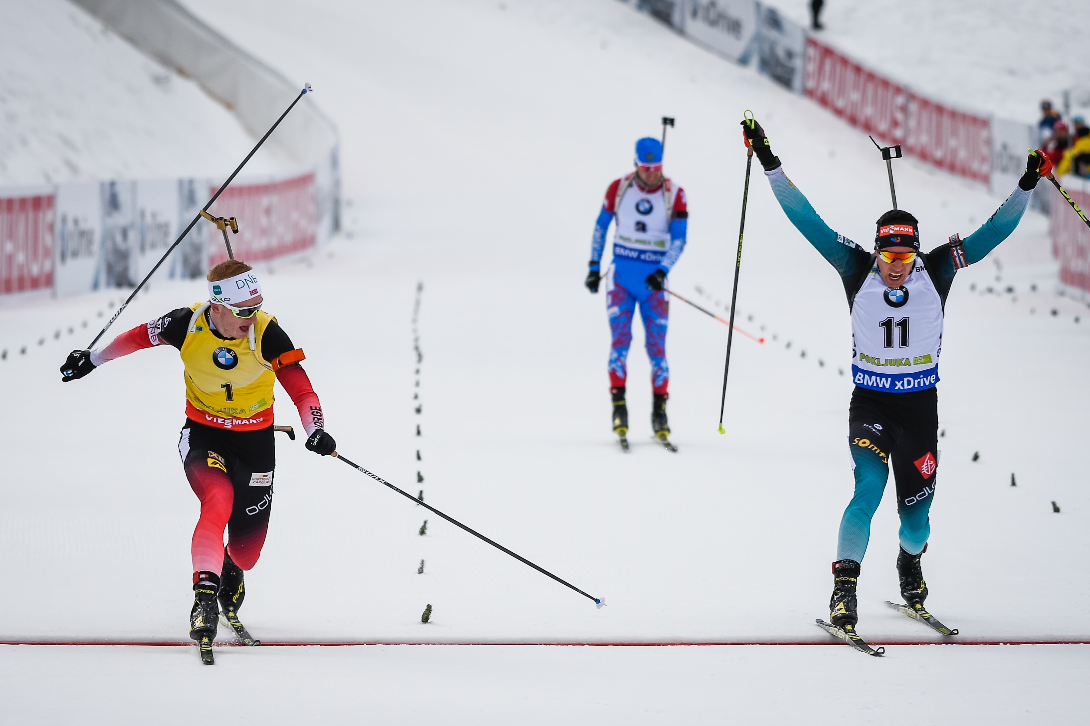 Johannes Thingnes Boe (L) of Norway crosses the finish line to win ahead of Quentin Fillon Maillet (R) of France during the IBU Biathlon World Cup Men's 12,5 km Pursuit competition in Pokljuka, on December 9, 2018