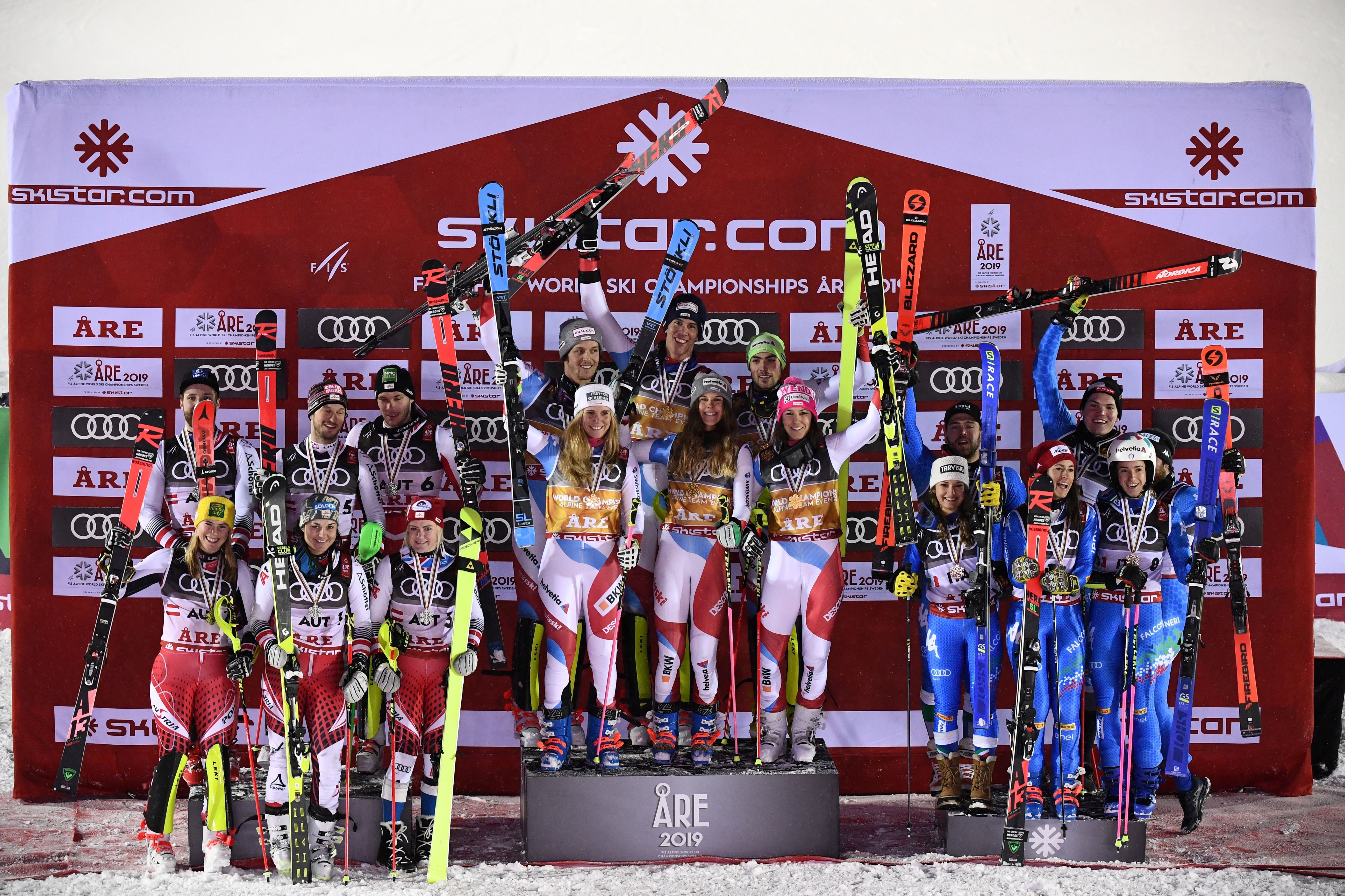 Winner Swiss team (C), second-placed Autrian team and third-placed Italian team celebrate after the Alpine team event at the 2019 FIS Alpine Ski World Championships at the National Arena in Are, Sweden, on February 12, 2019.