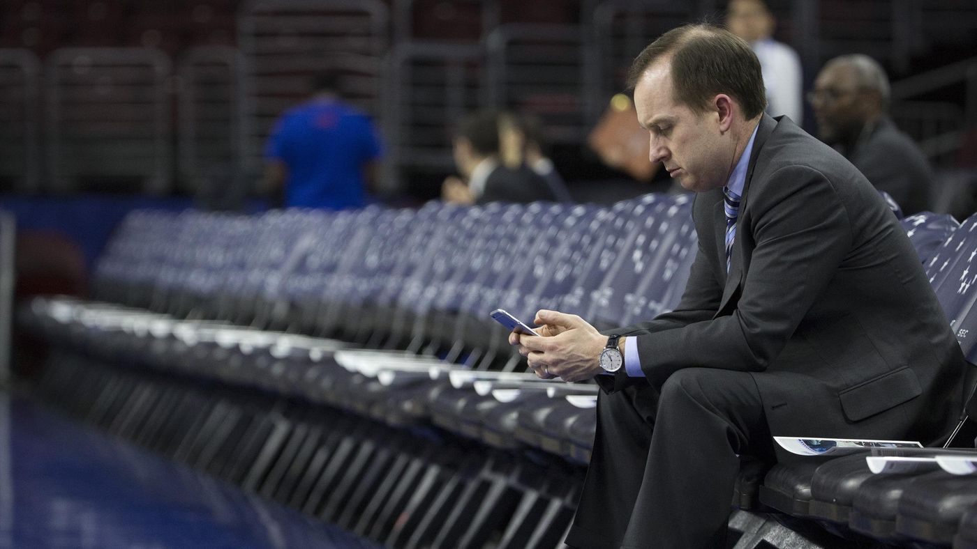 Philadelphia 76ers general manager Sam Hinkie looks down at his phone prior to the game against the Sacramento Kings on February 10, 2016 at the Wells Fargo Center in Philadelphia, Pennsylvania