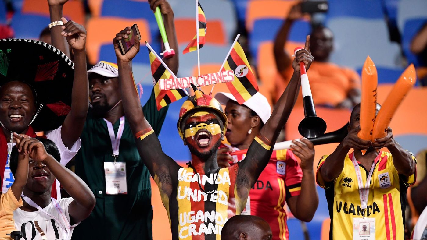 A Ugandan football fan wearing body paint and a hat showing his country's national colours and mascot as he holds a vuvuzela during the 2019 Africa Cup of Nations (CAN) Round of 16 football match between Uganda and Senegal at the Cairo International Stadi