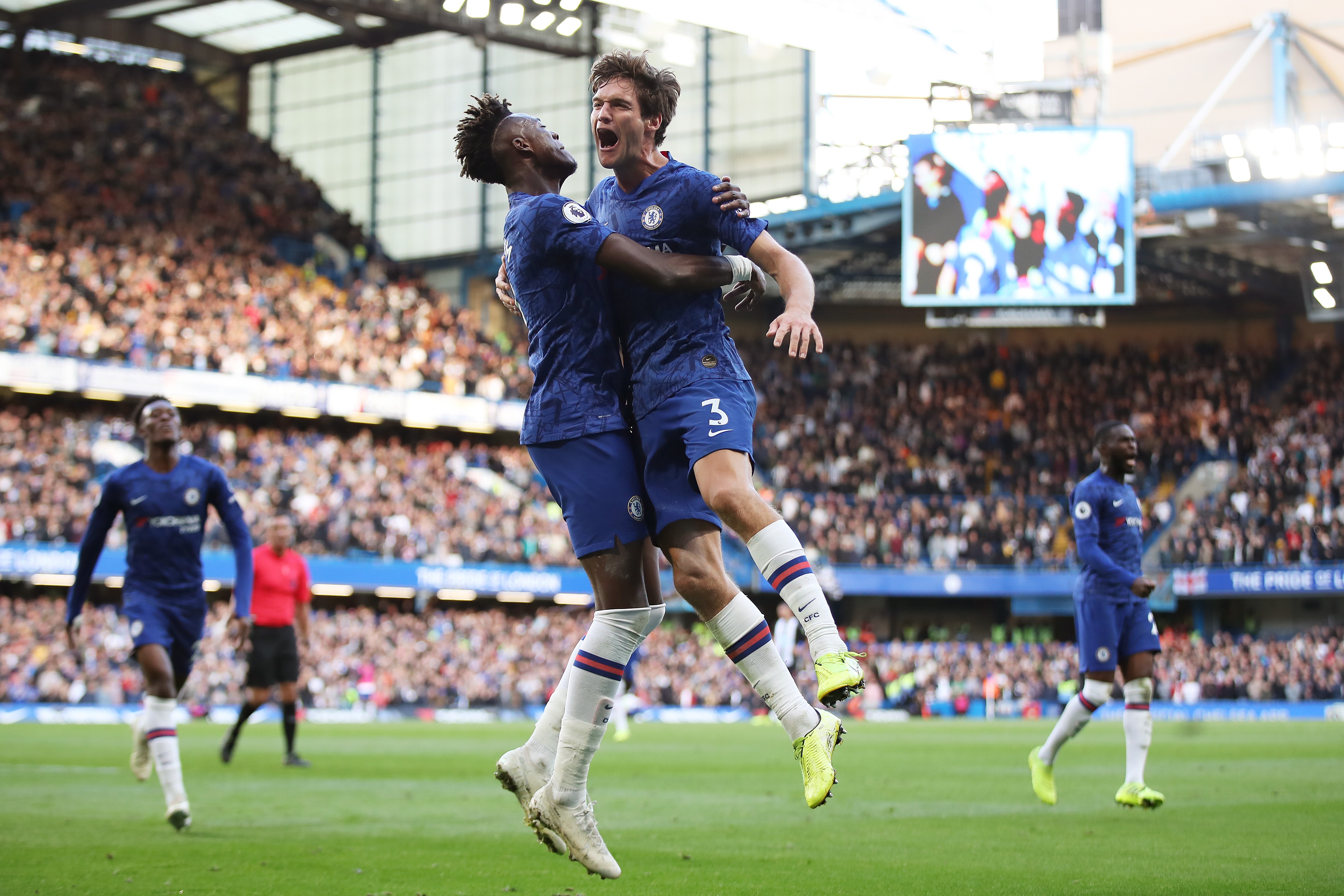 LONDON, ENGLAND - OCTOBER 19: Marcos Alonso of Chelsea celebrates with teammate Tammy Abraham after scoring his team's first goal during the Premier League match between Chelsea FC and Newcastle United at Stamford Bridge on October 19, 2019 in London, Uni