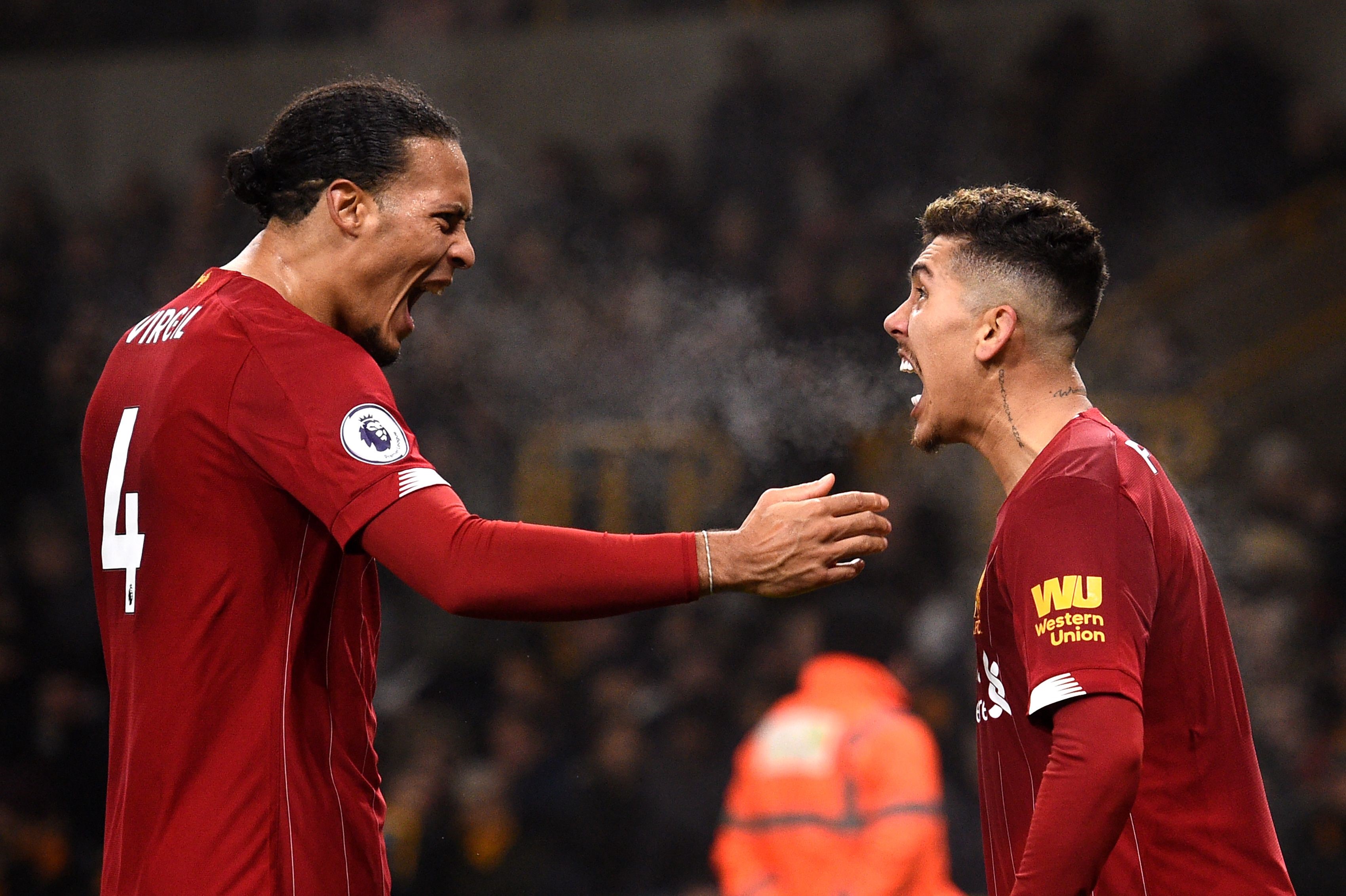 Liverpool's Brazilian midfielder Roberto Firmino (R) celebrates with teammates after he scores the team's second goal during the English Premier League football match between Wolverhampton Wanderers and Liverpool