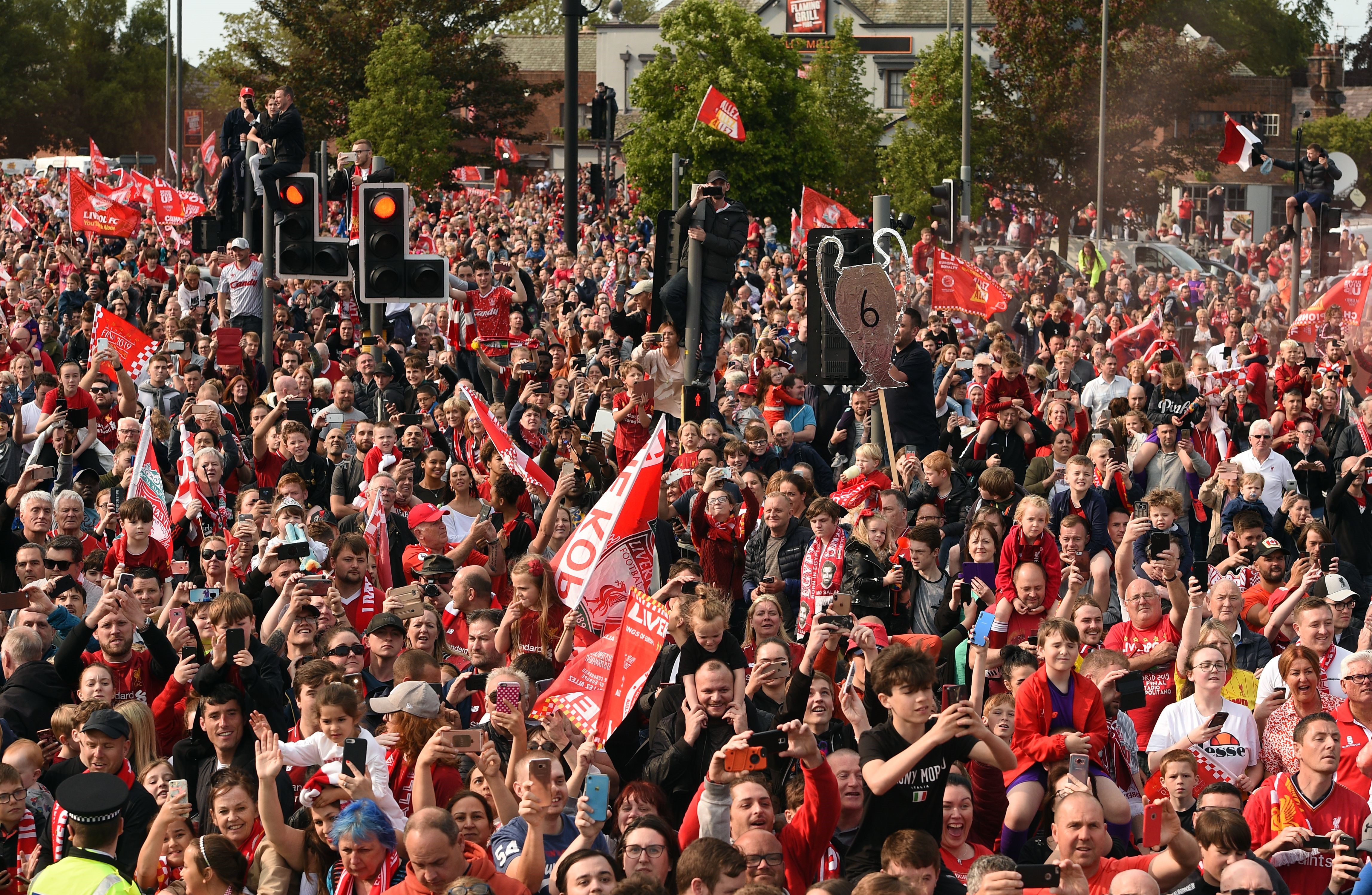 Football fans line the streets waiting to see the Liverpool football team take part in an open-top bus parade around Liverpool, north-west England on June 2, 2019, after winning they won the UEFA Champions League final football match between Liverpool and