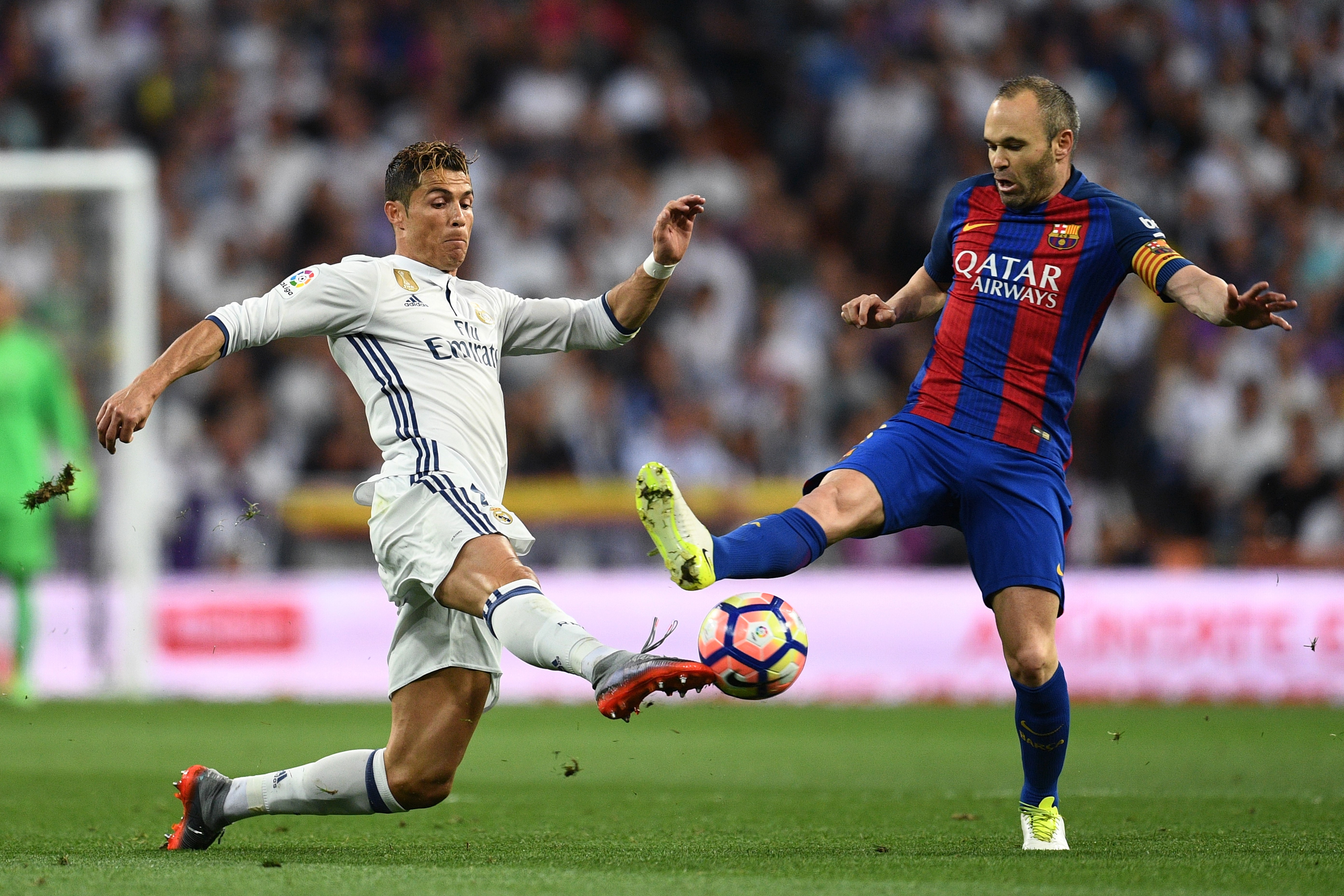 Andrés Iniesta y Cristiano Ronaldo pelean por un balón en el Clásico