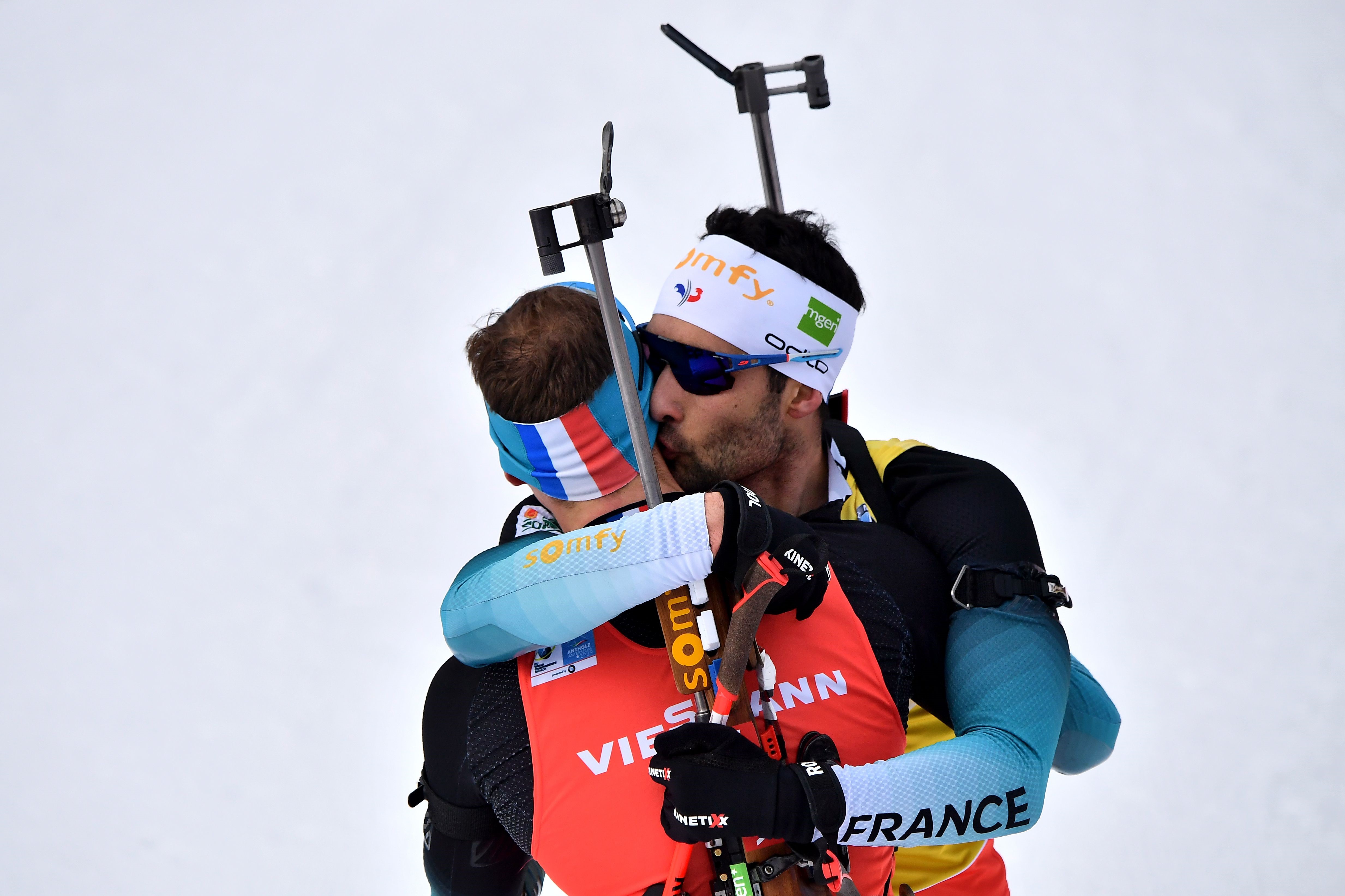 France's Martin Fourcade (R) embraces France's Emilien Jacquelin after Jacquelin won the IBU Biathlon World Cup 12.5 km Men's pursuit in Rasen-Antholz (Rasun Anterselva), Italian Alps, on February 16, 2020