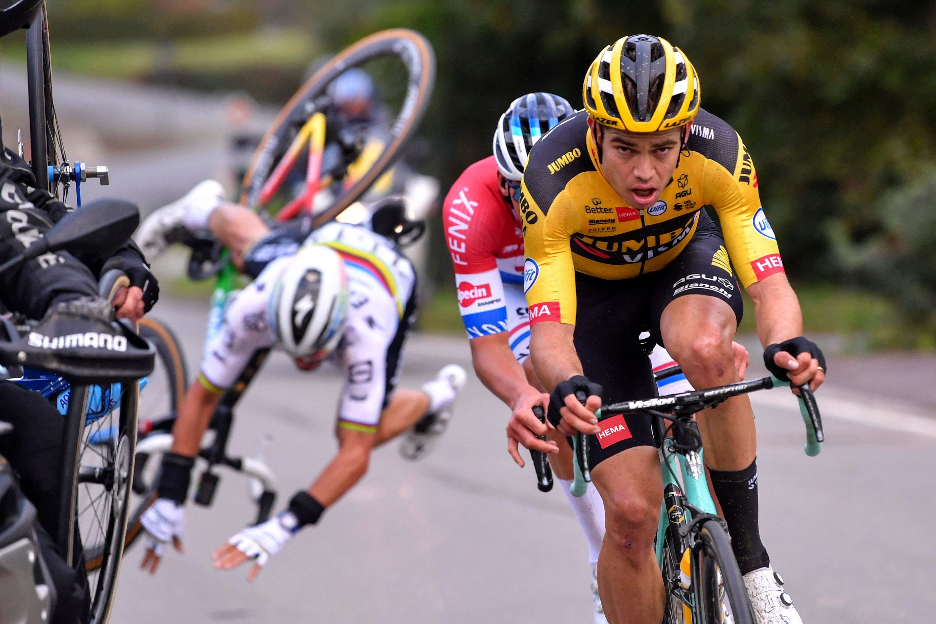 French Julian Alaphilippe (back) of Deceuninck - Quick-Step falls after touching a motorcyclist, as he rides behind Belgian Wout Van Aert of Team Jumbo-Visma and Dutch Mathieu van der Poel of Alpecin-Fenix during the 'Ronde van Vlaanderen or Tour of Fland