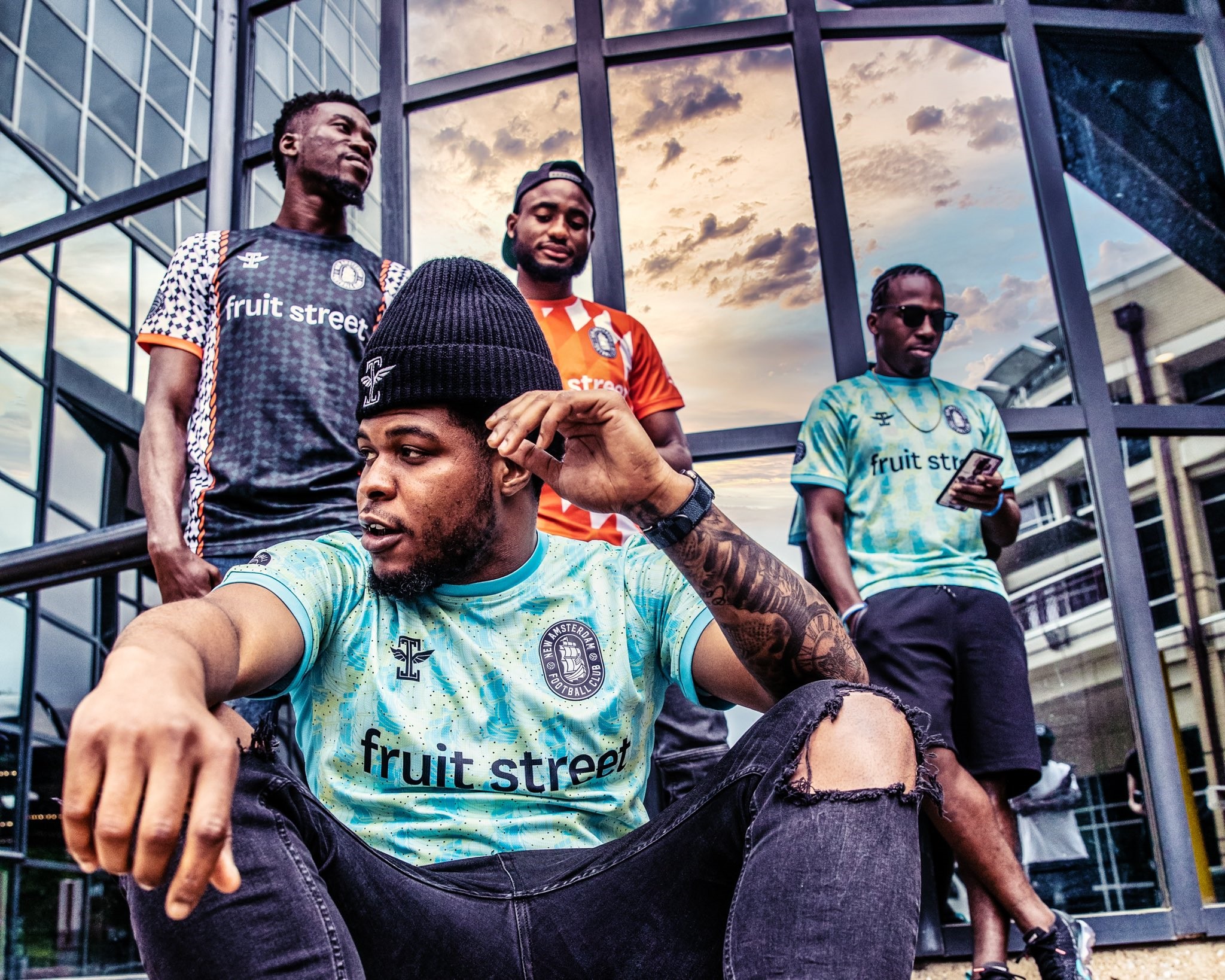 Des joueurs du New Amsterdam FC posent devant un immeuble de New York