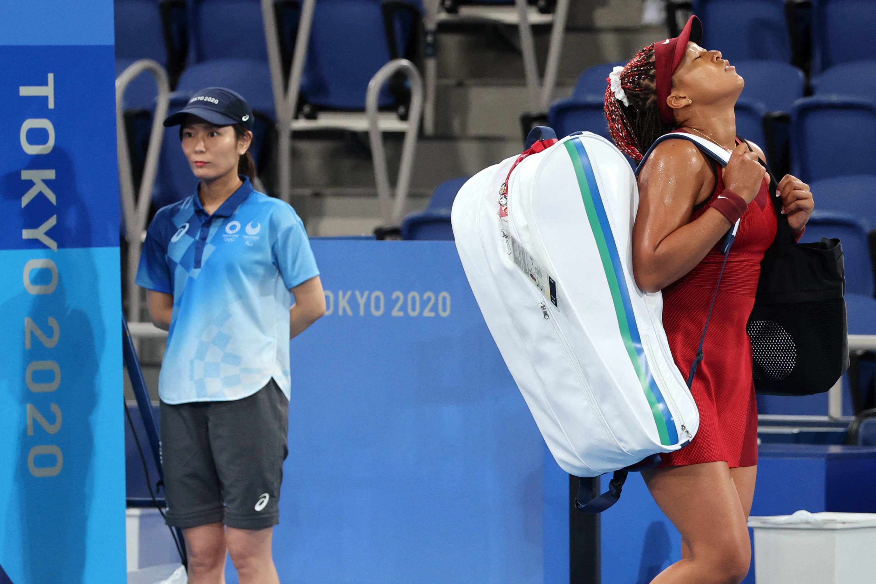 Japan's Naomi Osaka leaves the court after being beaten by Czech Republic's Marketa Vondrousova during their Tokyo 2020 Olympic Games women's singles third round tennis match at the Ariake Tennis Park