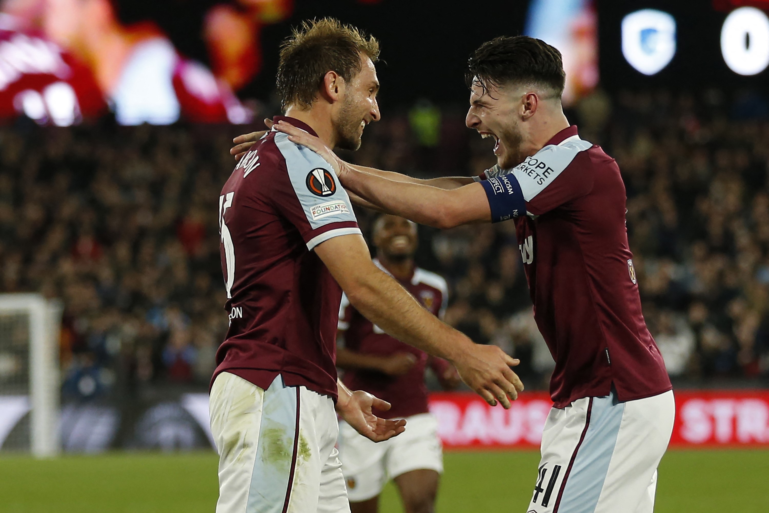 West Ham United's English defender Craig Dawson (L) celebrates with West Ham United's English midfielder Declan Rice (R) after scoring the opening goal of the UEFA Europa League group H football match between West Ham United and Genk at The London Stadium