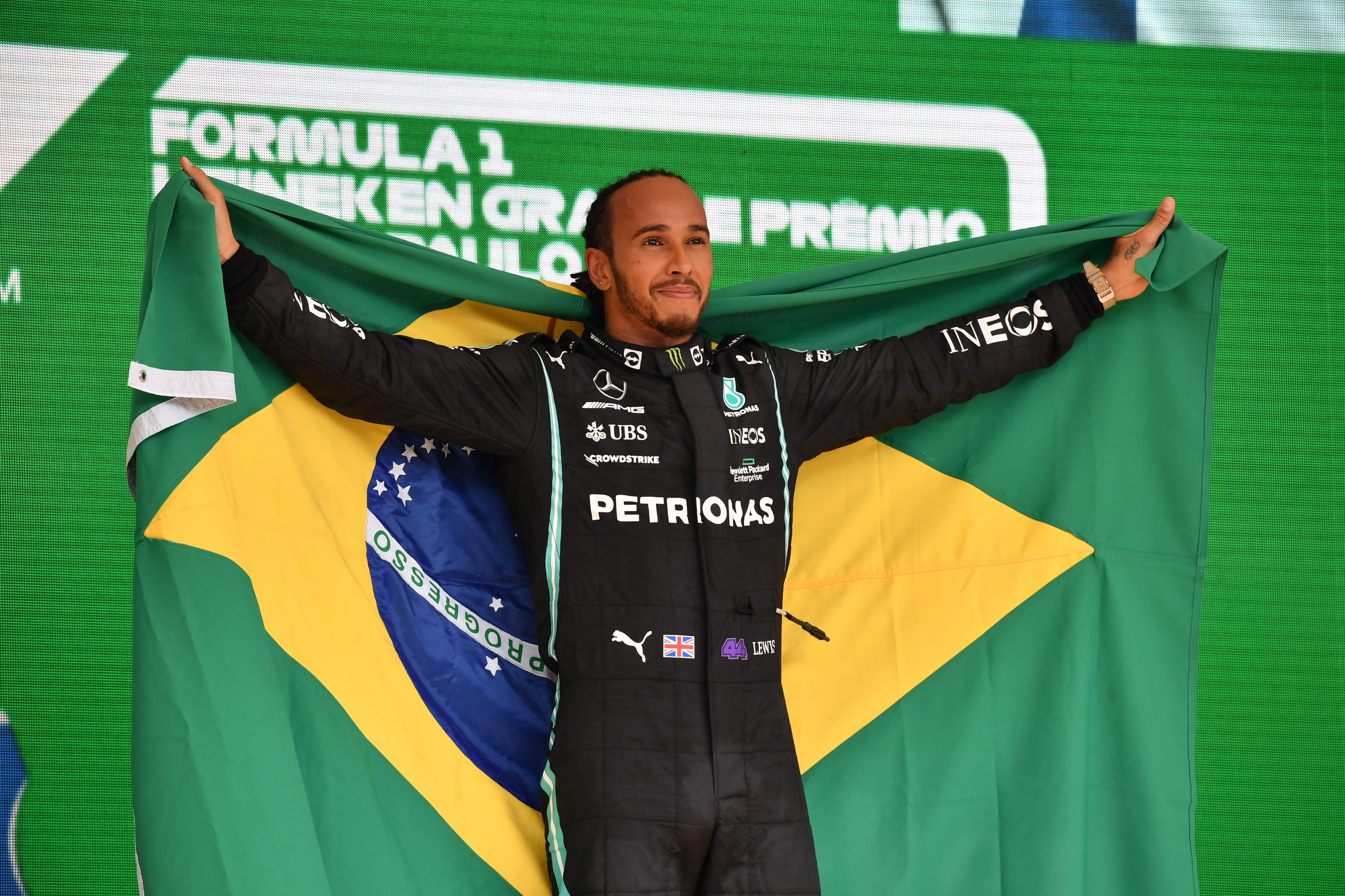 Mercedes' British driver Lewis Hamilton celebrates on the podium after winning Brazil's Formula One Sao Paulo Grand Prix at the Autodromo Jose Carlos Pace, or Interlagos racetrack, in Sao Paulo, on November 14, 2021. (Photo by NELSON ALMEIDA / AFP)