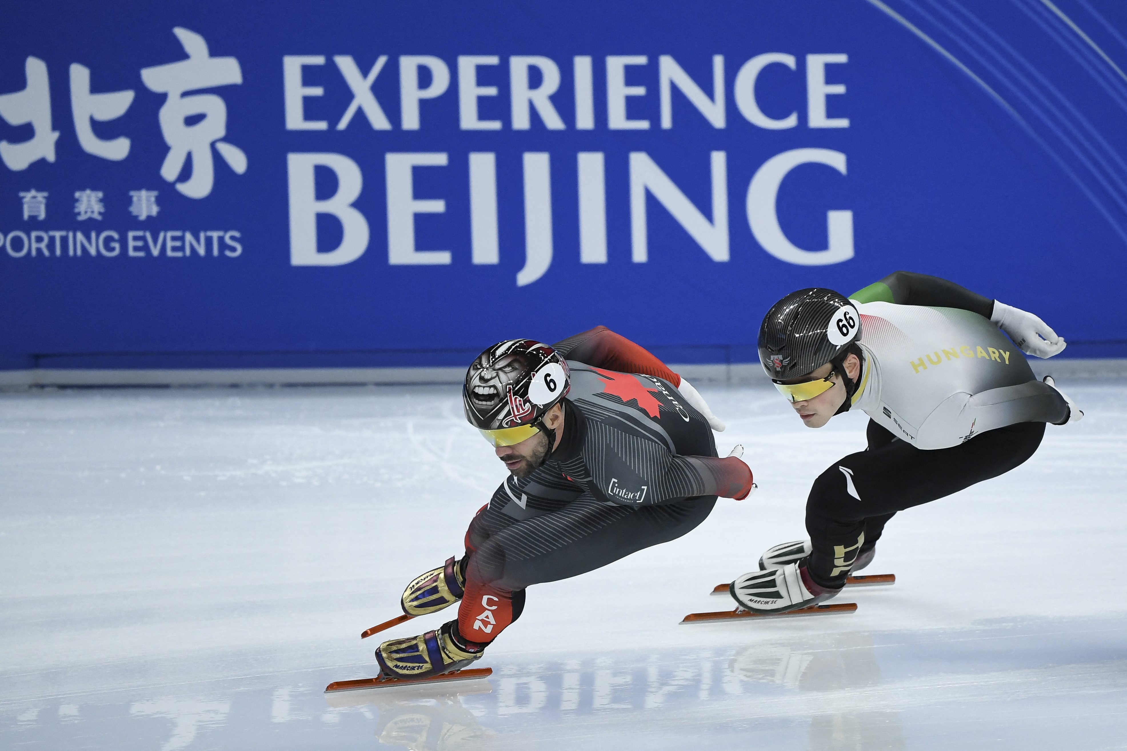 Charles Hamelin (L) and Hungary's John-Henry Krueger compete in the men's 1500m quarter finals during the 2021/2022 ISU World Cup short track speed skating, part of a 2022 Beijing Winter Olympic Games test event, at the Capital Indoor Stadium in Beijing o