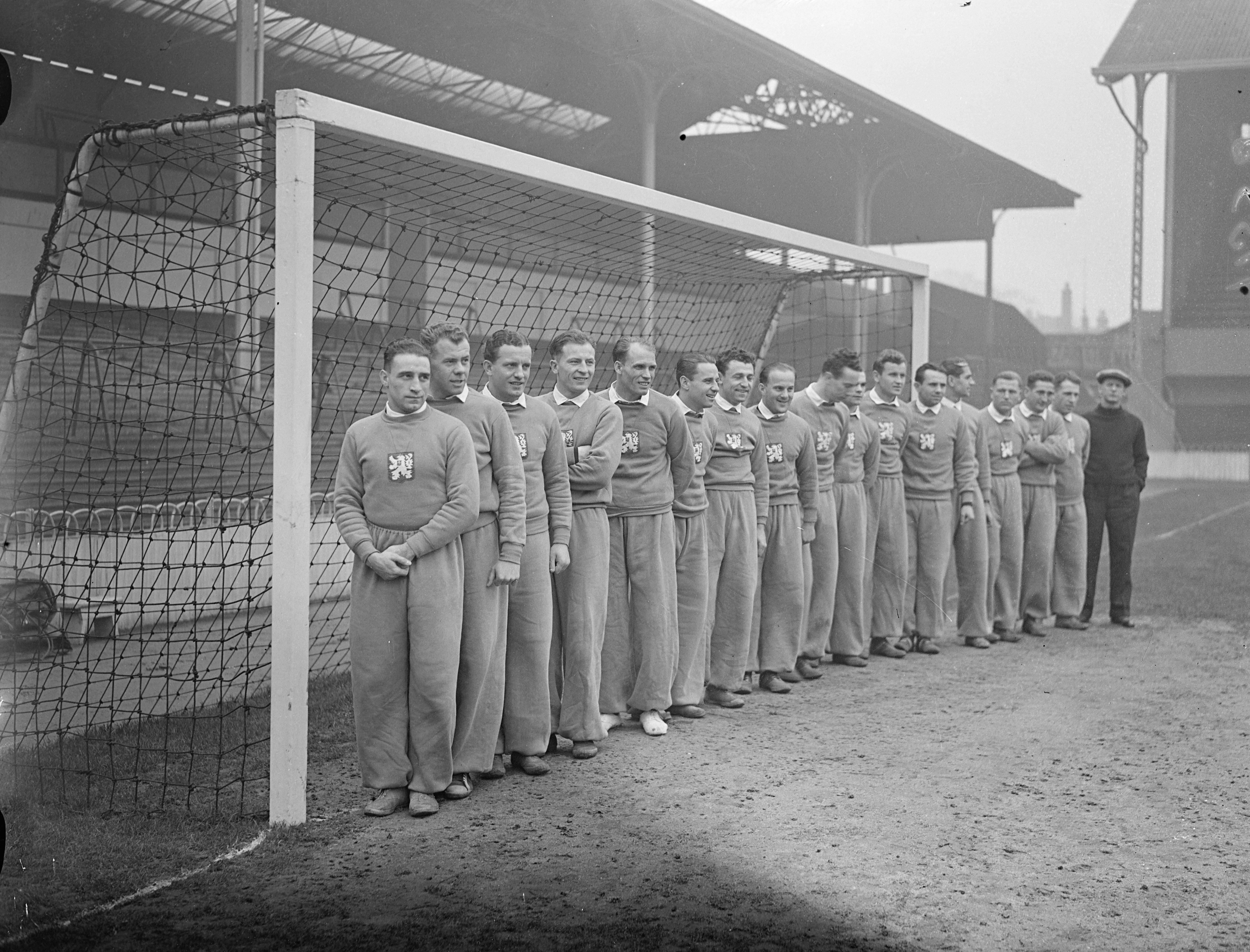 Los futbolistas de Checoslovaquia se entrenan en el estadio del Tottenham Hostpur, White Hard Lane, antes de enfrentarse a Inglaterra en el primer partido internacional entre ambas selecciones. La foto muestra a los jugadores checos alineados para una foto de equipo. Orden desconocido: Antonin Puc, Karel Kolsky, Antonin Vodicka, Oldrich Nejedly, Jan Riha, Jaroslav Boucek, Frantisek Planicka (capitán), Frantisek Kloz, Josef Zeman, Josef Kostalek, Ferdinand Daucik y el entrenador Tesar. 30 de noviembre de 1937, Reino Unido, Inglaterra