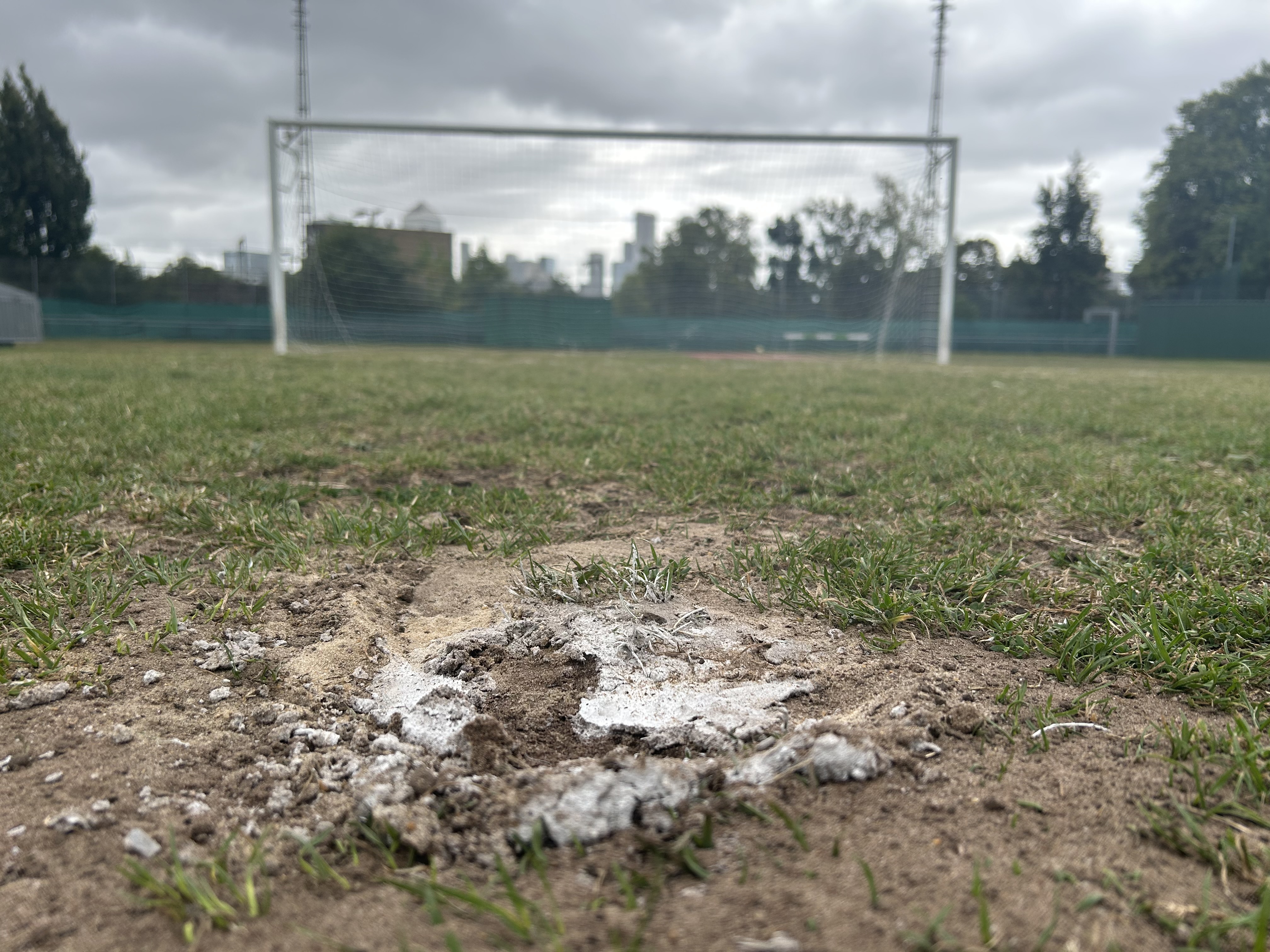 A view from the penalty spot at Mile End Stadium, with Canary Wharf in the background