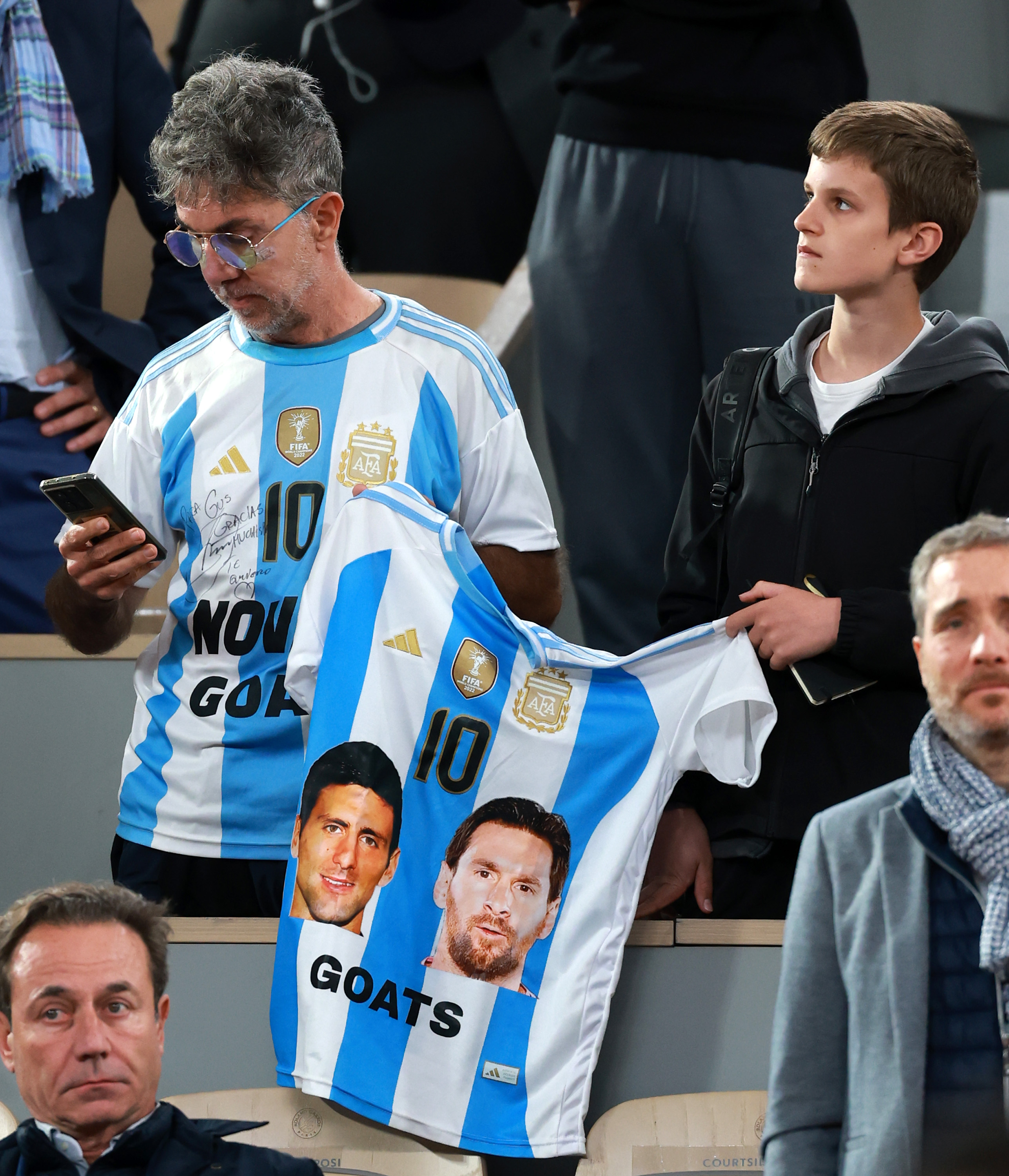 A fan shows his support for Novak Djokovic of Serbia and Lionel Messi of Argentina as he plays against Mackenzie McDonald of United States in the Men's Singles First Round match during Day Three of the 2025 French Open at Roland Garros on May 27, 2025 in Paris, France.