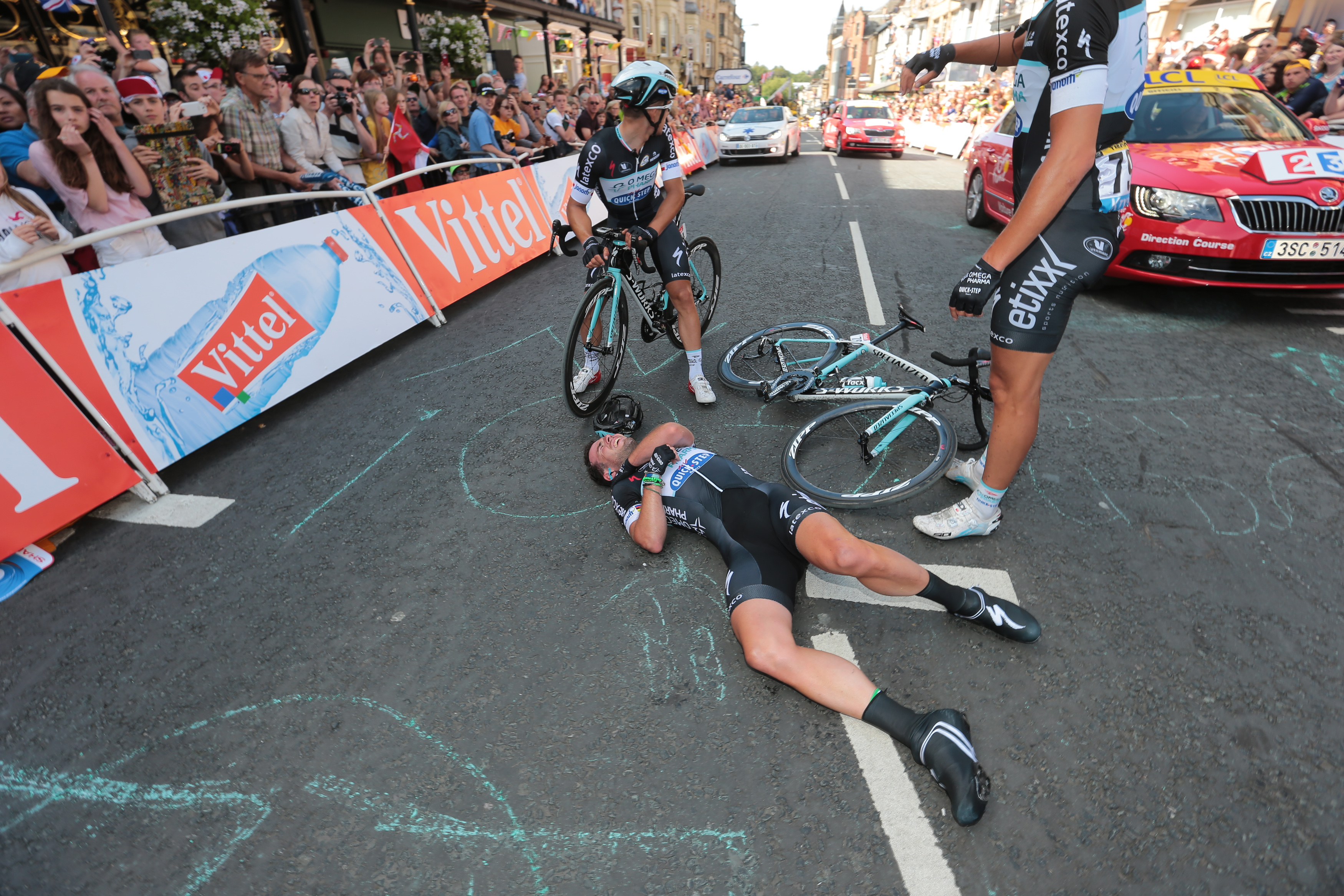 Mark Cavendish of Britain gets assistance after crashing