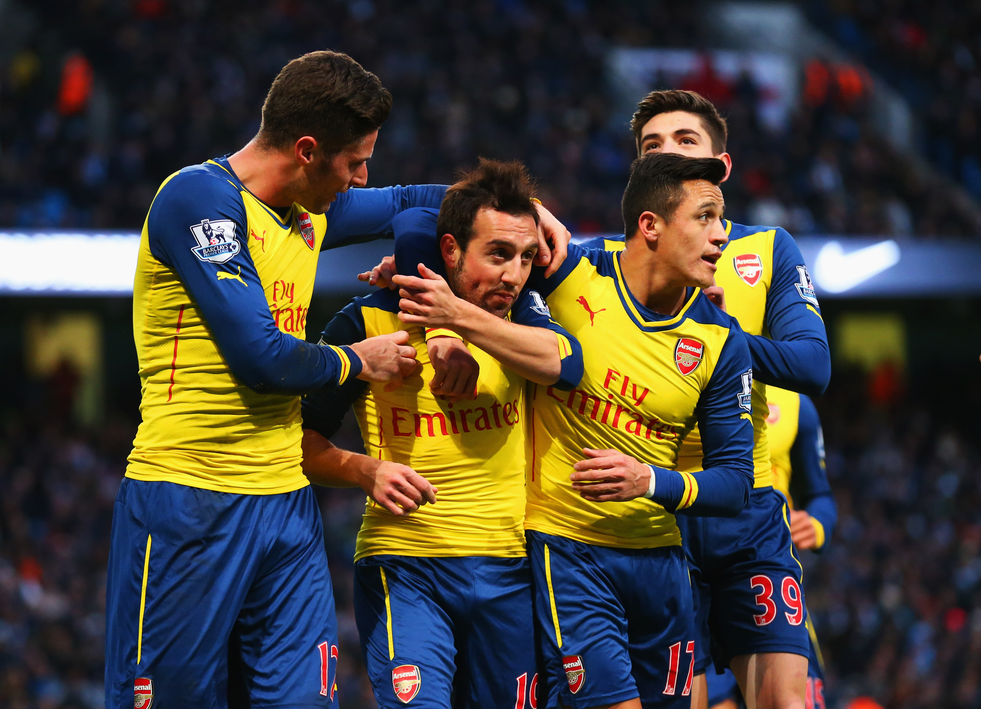 MANCHESTER, ENGLAND - JANUARY 18: Santi Cazorla of Arsenal (2L) celebrates with team mates